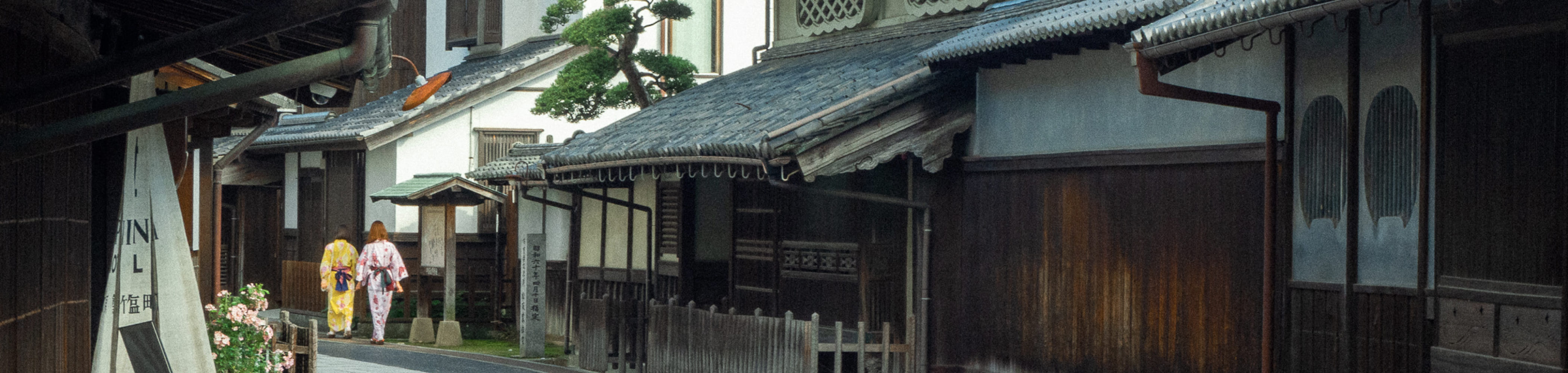 写真：竹原市の古風な街並み。参道を浴衣を着た女性が歩いている。