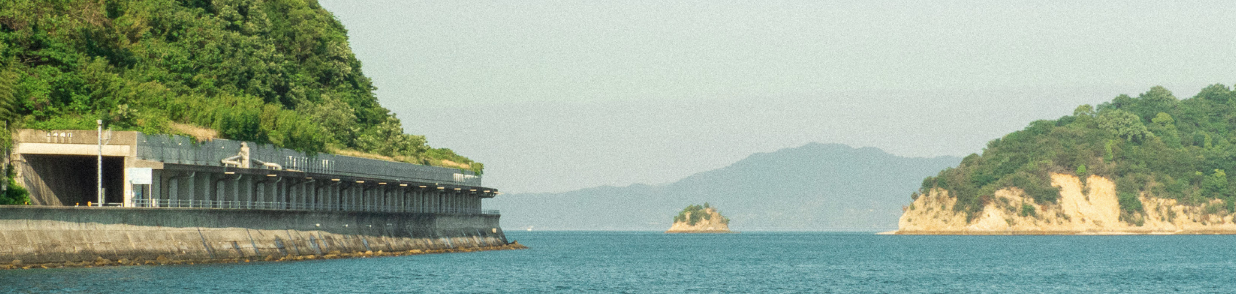 写真：瀬戸内海の風景。穏やかな海をメインに、島がいくつか映り込んでいる。